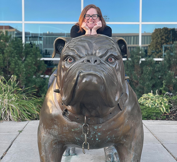 Senior Sydney Baltuck sitting cross legged outside the Myrtle Woldson Performing Arts Center.